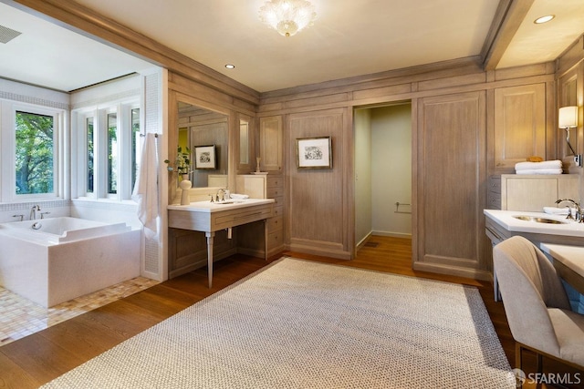 bathroom with vanity, wood finished floors, and a garden tub