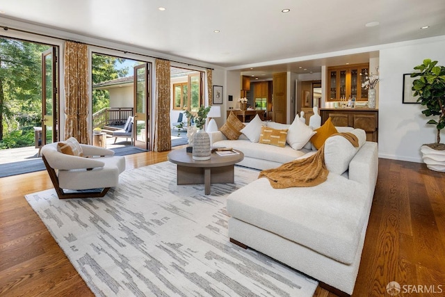 living room with recessed lighting, baseboards, and wood finished floors