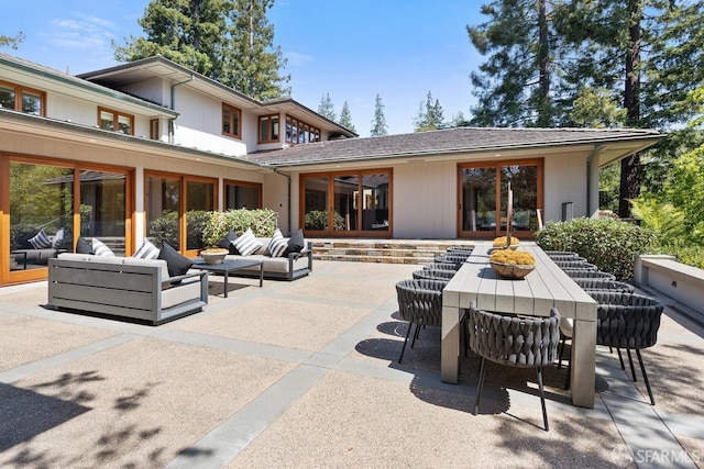 back of property with outdoor lounge area and a patio