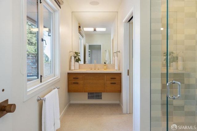 full bath with vanity, visible vents, baseboards, and a stall shower