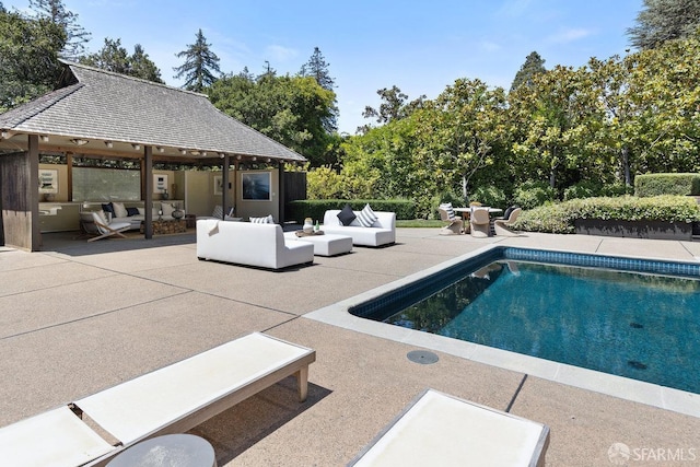 pool with an outdoor living space, a gazebo, and a patio area