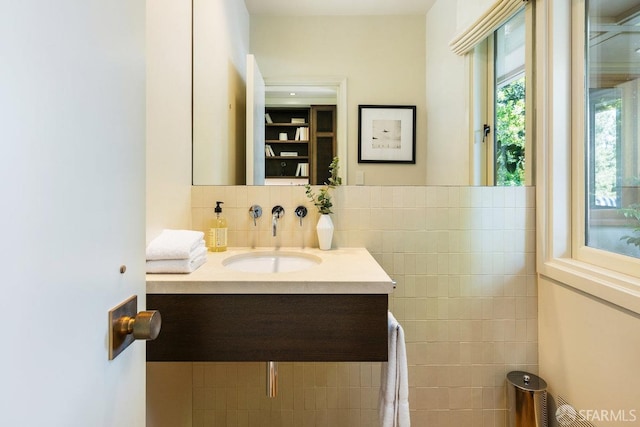 bathroom with vanity, backsplash, and tile walls