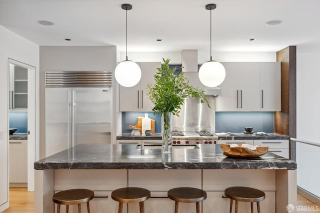 kitchen with an island with sink, a breakfast bar, and pendant lighting