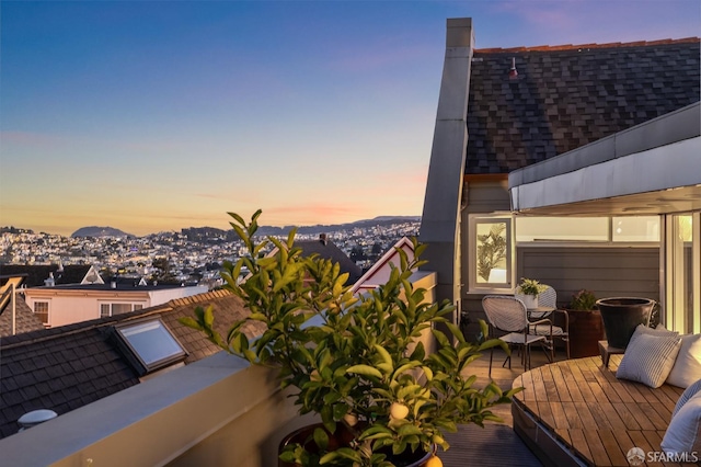 balcony at dusk featuring a deck with mountain view