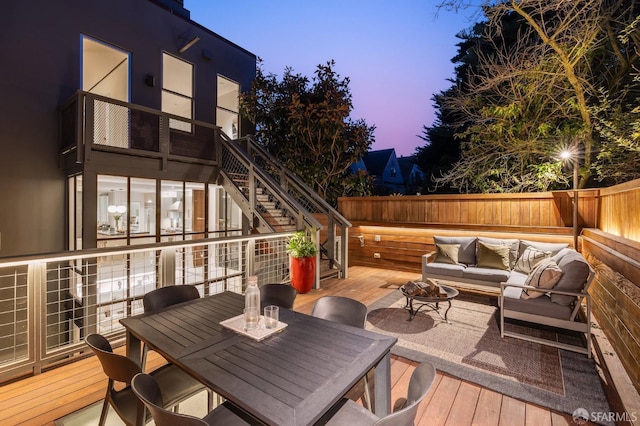 deck at dusk featuring an outdoor living space with a fire pit