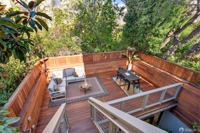 wooden terrace featuring an outdoor living space with a fire pit