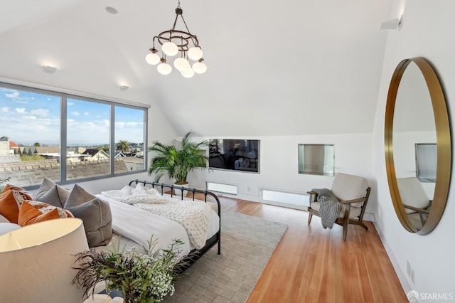 bedroom featuring lofted ceiling, light hardwood / wood-style floors, and an inviting chandelier