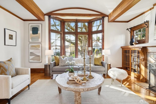 living room featuring light parquet flooring, beamed ceiling, and a healthy amount of sunlight