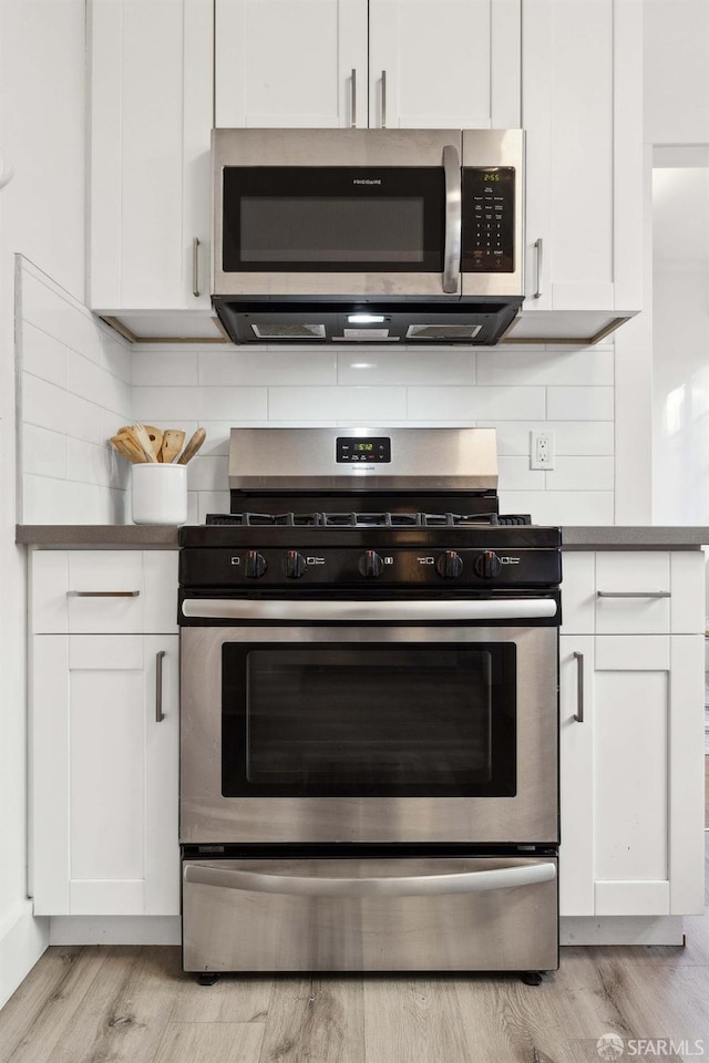 kitchen featuring tasteful backsplash, white cabinets, and appliances with stainless steel finishes