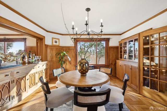 dining area featuring light parquet floors, ornamental molding, and an inviting chandelier