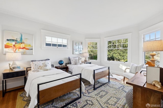 bedroom with ornamental molding and hardwood / wood-style floors