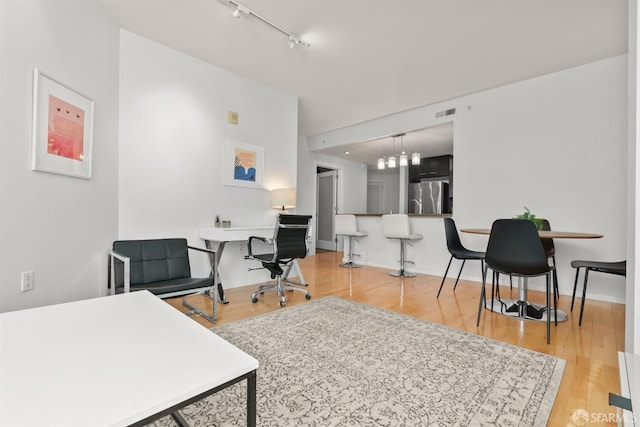 office featuring wood-type flooring and an inviting chandelier