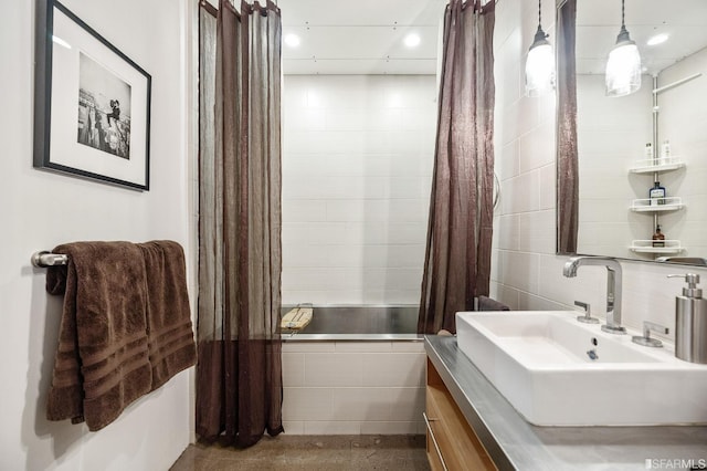 bathroom with shower / tub combo with curtain, sink, and tile walls