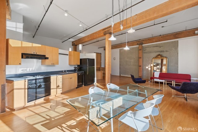 kitchen featuring light brown cabinets, sink, light hardwood / wood-style floors, pendant lighting, and black appliances