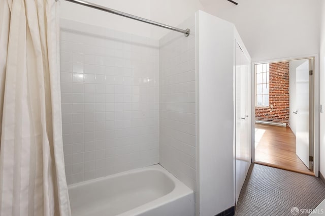 bathroom with shower / bathtub combination with curtain and brick wall