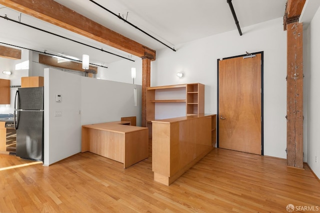 kitchen with light wood-type flooring, refrigerator, and kitchen peninsula