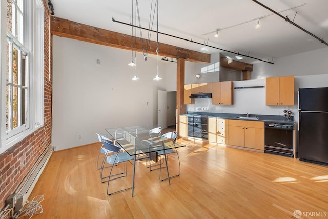 kitchen featuring light brown cabinetry, brick wall, baseboard heating, black appliances, and light hardwood / wood-style floors