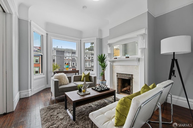 living room with a brick fireplace and dark wood-type flooring