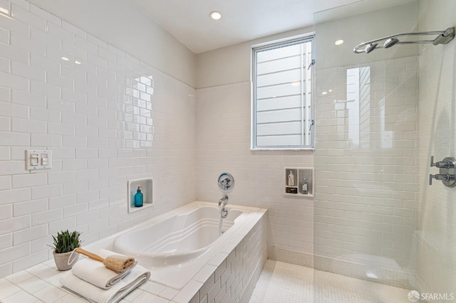 bathroom featuring tile patterned floors, independent shower and bath, and tile walls