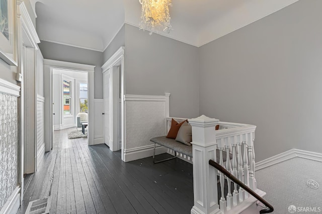 corridor with dark hardwood / wood-style flooring and a chandelier