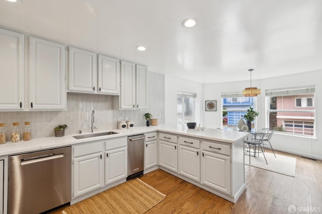 302 Warren Dr, San Francisco, CA 94131 - kitchen with stainless steel dishwasher, a peninsula, light countertops, light wood-type flooring, and tasteful backsplash