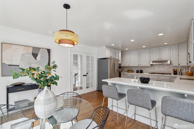 302 Warren Dr, San Francisco, CA 94131 - kitchen featuring gas stovetop, freestanding refrigerator, under cabinet range hood, french doors, and light countertops