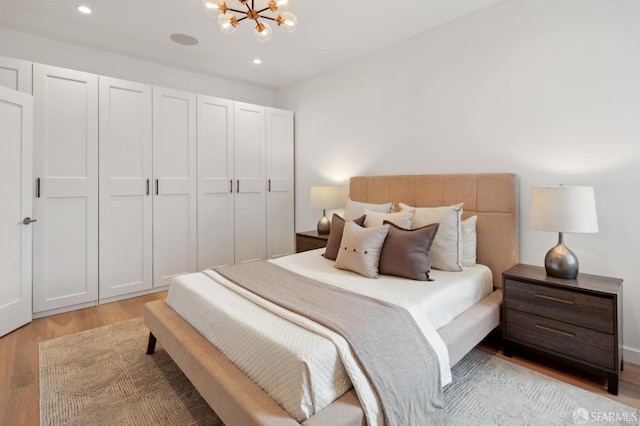 bedroom featuring a chandelier and light hardwood / wood-style flooring