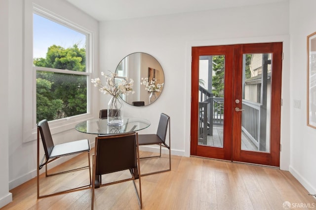 dining area with french doors, plenty of natural light, and light hardwood / wood-style flooring