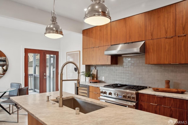 kitchen featuring sink, high end stainless steel range oven, decorative backsplash, decorative light fixtures, and french doors