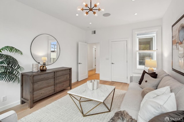 living room featuring a chandelier and light wood-type flooring