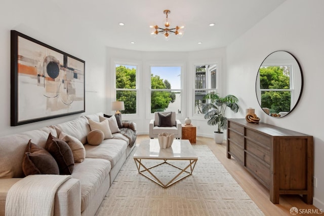 living room with light hardwood / wood-style flooring and a notable chandelier