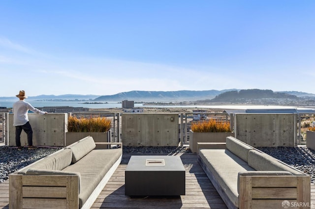 wooden terrace featuring a mountain view and an outdoor living space