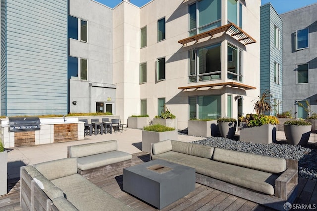 view of patio featuring exterior bar, an outdoor hangout area, area for grilling, and a grill