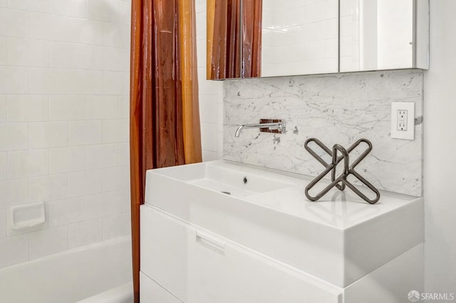 bathroom featuring vanity and tasteful backsplash