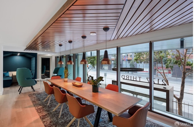 dining space with wood ceiling, a wealth of natural light, and light wood-type flooring