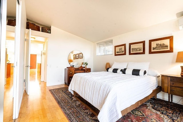 bedroom with light wood-type flooring and lofted ceiling