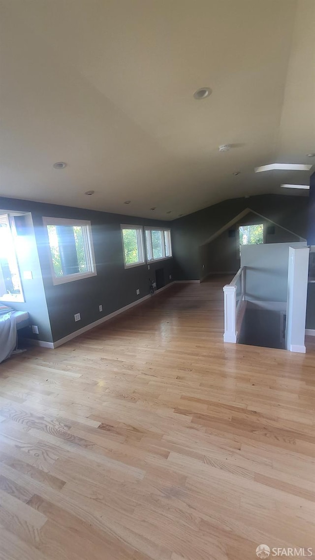 unfurnished living room featuring light hardwood / wood-style flooring and vaulted ceiling