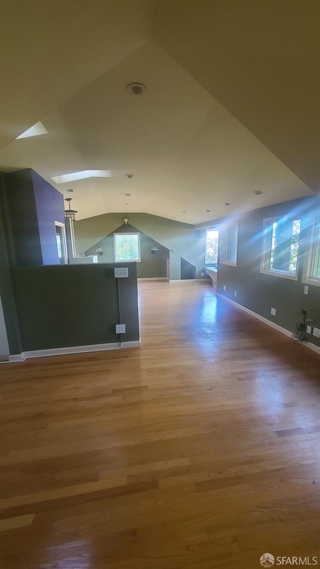 additional living space featuring hardwood / wood-style flooring and vaulted ceiling