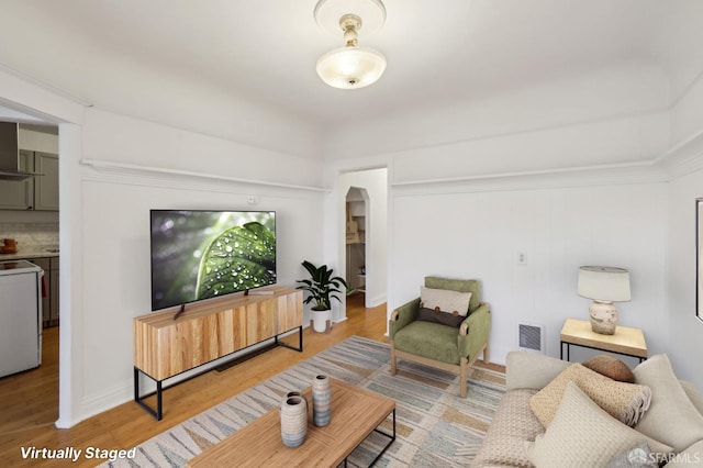 1527 Palou Ave, San Francisco, CA 94124 - living room with arched walkways, wood finished floors, and baseboards
