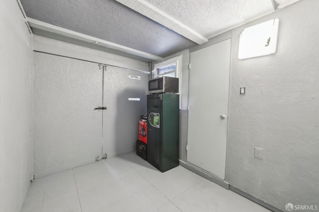 1527 Palou Ave, San Francisco, CA 94124 - below grade area featuring a textured ceiling, a textured wall, and tile patterned floors