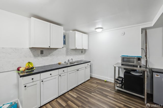 1527 Palou Ave, San Francisco, CA 94124 - kitchen with a sink, backsplash, dark countertops, white cabinets, and dark wood-style flooring