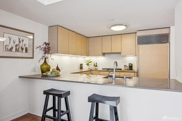 301 Mission St Unit 6J, San Francisco, CA 94105 - kitchen featuring paneled built in refrigerator, light brown cabinets, a peninsula, a breakfast bar area, and dark wood-style flooring
