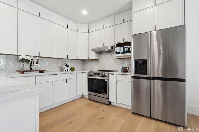 31 Romolo Pl Unit 6, San Francisco, CA 94133 - kitchen with light wood-style flooring, under cabinet range hood, stainless steel appliances, white cabinets, and decorative backsplash