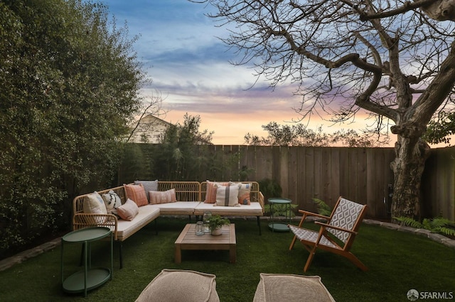 patio terrace at dusk with outdoor lounge area and a yard