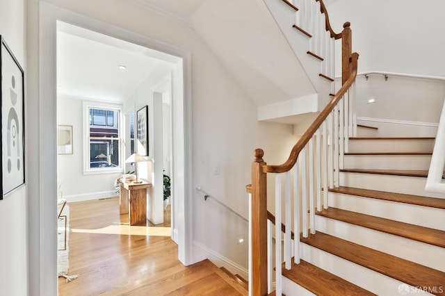 staircase with hardwood / wood-style flooring and crown molding