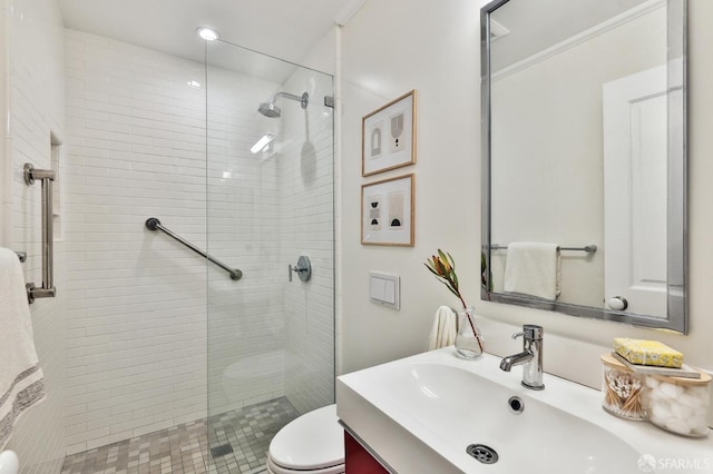 bathroom with ornamental molding, tiled shower, toilet, and vanity