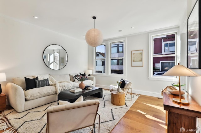 living room with light hardwood / wood-style flooring and ornamental molding