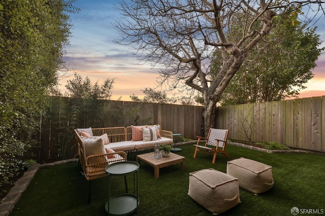 patio terrace at dusk with a lawn and outdoor lounge area