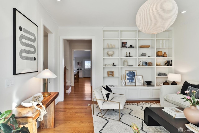 living room featuring light hardwood / wood-style flooring and crown molding