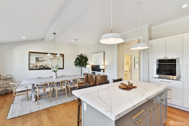 kitchen with decorative light fixtures, white cabinets, lofted ceiling with beams, oven, and a center island